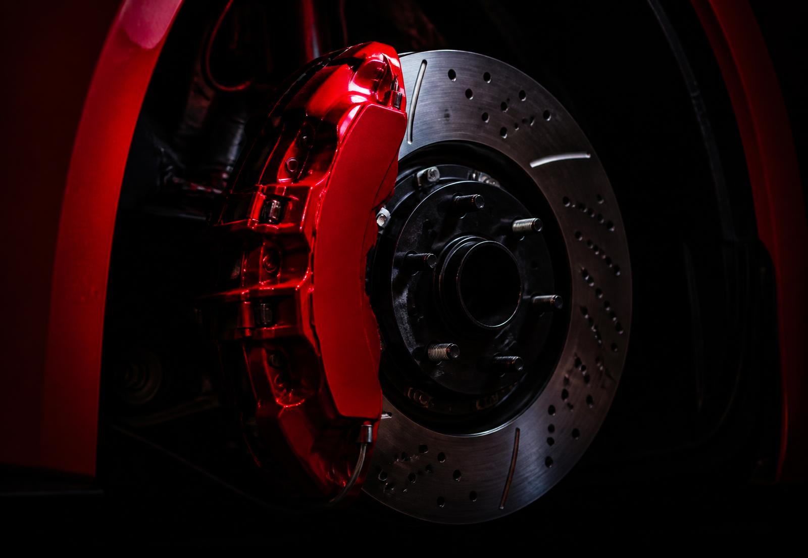 Red brake caliper on a drilled and slotted rotor
